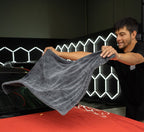 Drying a red car bonnet with the XL Dry Guy microfibre towel in the Deluxe Detail studio