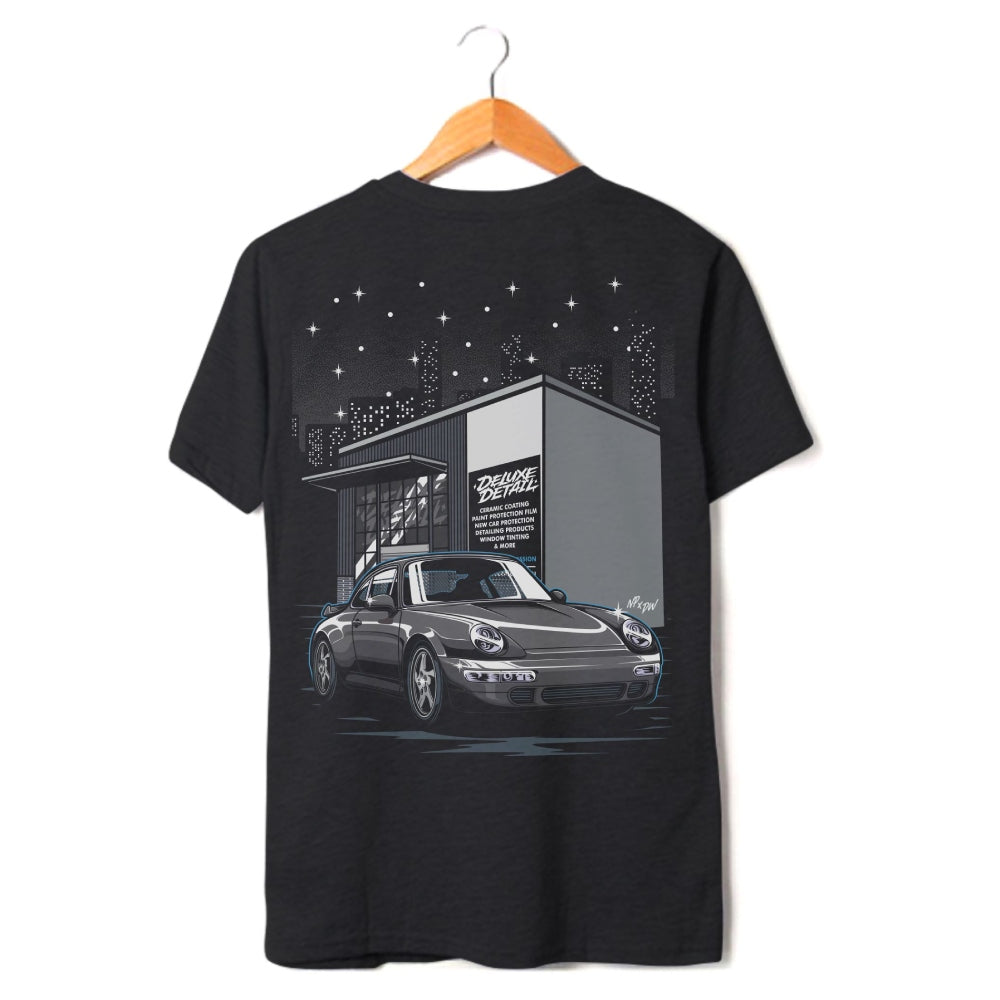Deluxe Detail '911' t-shirt in black on a hanger, back print of a Porsche 911 outside the studio