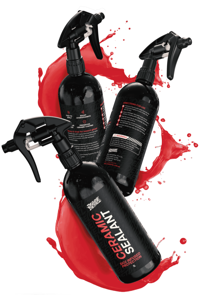 Three bottles of Deluxe Detail CERAMIC SEALANT suspended in a red liquid splash on a black background