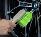 Cleaning the face of a wet BMW alloy wheel with the green bristled wheel face brush