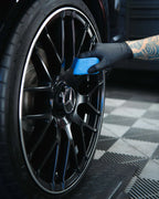 Coating a black Mercedes-AMG alloy wheel by hand with a microfibre applicator
