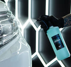 Spraying Deluxe Detail Quick Detailer over a white car in the Deluxe Detail studio